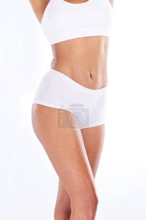 Téléchargez les photos : Health, diet and flat stomach, woman with tummy tuck, skinny waist and isolated on white background. Fitness, healthcare and wellness, slim figure girl and liposuction or weightloss workout in studio. - en image libre de droit