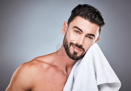 Photo pour Skincare, health and portrait of a man in a studio with a cosmetic, natural and face routine. Wellness, healthy and handsome male model with a facial towel for treatment isolated by a gray background. - image libre de droit
