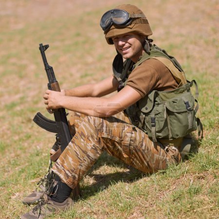 Photo for He found his calling. A young soldier sitting on the grass outside - Royalty Free Image
