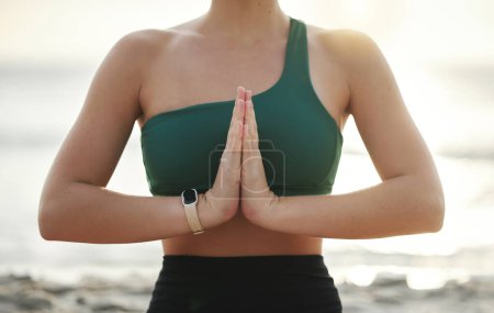 Téléchargez les photos : Woman, hands and yoga in meditation on the beach for spiritual wellness, zen or workout in the outdoors. Hand of female yogi meditating or namaste for calm, peaceful mind or awareness by the ocean. - en image libre de droit