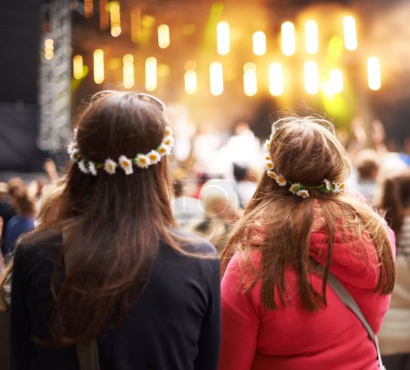Foto de Glad to be at the show. Rear-view shot of a crowd at an outdoor music festival with the focus on two female fans - Imagen libre de derechos