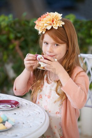 Téléchargez les photos : Hostess of the tea party. A cute little girl having a tea party outside - en image libre de droit