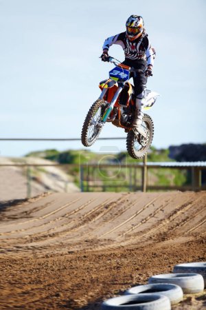 Photo for On his way to becoming a champion. A motocross rider mid-air during a jump - Royalty Free Image