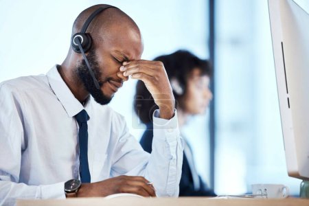Depression, burnout and stress by call center worker, employee and customer service consultant in office. Pain, mental health and headache telemarking agent overworked and frustrated at the workplace.