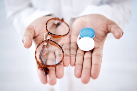 Photo for Eye care, choice with glasses or contact lenses in hands, closeup and vision with healthcare for eyes. Prescription lens, person with frame and plastic container, optometry with optician and health. - Royalty Free Image