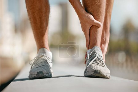 Photo for Ankle pain of runner or man hands for fitness healthcare risk, muscle accident or training problem in city. Running, cardio and workout foot injury of athlete person stop in street for legs massage. - Royalty Free Image