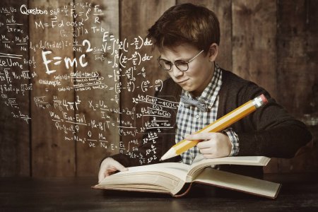 Foto de Hmm, this is a tricky problem...a young boy doing his maths homework - Imagen libre de derechos
