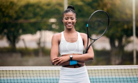 Photo for Portrait of a proud tennis player on the court. Young tennis player arms crossed standing on the court. Happy player holding her tennis racket. Young african american tennis player. - Royalty Free Image