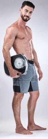 Photo for Fitness, exercise or man weight scale in studio after body training or gym workout for wellness goals. Healthy, progress or motivation with a male athlete in a club to monitor exercising performance. - Royalty Free Image