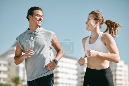 Couple, fitness and smile running in the city for exercise, workout or cardio routine together in Cape Town. Happy man and woman runner taking a walk or jog for healthy wellness or exercising outside.
