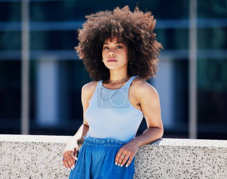 Portrait, fashion and attitude with a black woman in the city, outdoor on a bridge during a summer day. Street, style or urban and an attractive young female posing outside with an afro hairstyle.