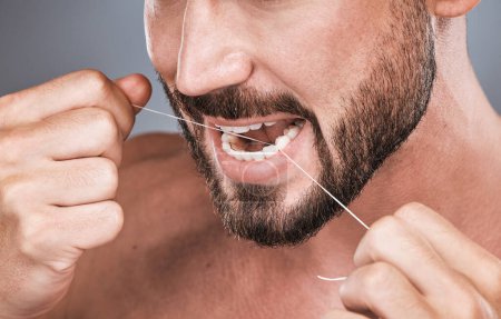 Téléchargez les photos : Mouth floss, tooth and man in studio for beauty, healthy body care and hygiene on background. Closeup of male, teeth flossing and cleaning face for facial wellness, fresh breath and dental cosmetics. - en image libre de droit