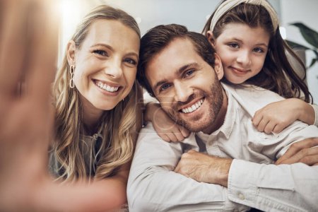 Téléchargez les photos : Portrait, love or parents take a selfie with a girl as a happy family in house living room bonding in Australia. Mother, father or child relaxing with a smile enjoying quality time or taking pictures. - en image libre de droit