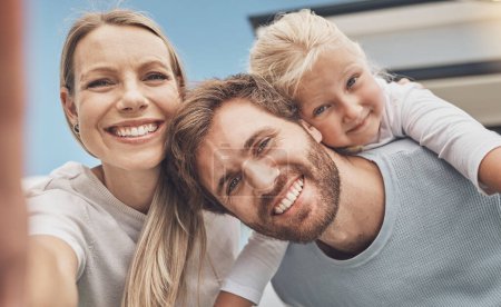 Foto de Selfie, happy and portrait of a family at their house after moving, relocation and buying a home. Real estate, mortgage and face of a mother, father and child with a photo outside of a new apartment. - Imagen libre de derechos