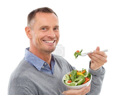 Photo for Portrait, food and salad with a man in studio isolated on a white background eating vegetables for health. Green, nutrition or diet with a happy mature male indoor to eat an organic meal for wellness. - Royalty Free Image