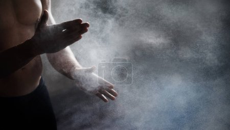 Foto de Magnesium, chalk and bodybuilder hands preparing for a workout or weight training at the gym. Fitness, talc and male athlete getting ready for bodybuilding exercise in sports center with mockup space. - Imagen libre de derechos