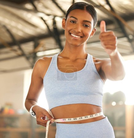 Téléchargez les photos : Another day, another diet goal smashed. Portrait of a fit young woman measuring her waistline in a gym - en image libre de droit