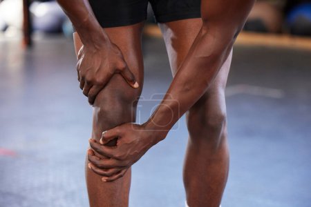 Hands, knee pain and man at gym with injury, hurt or sore during fitness, training and exercise on mockup space. Sports, accident and legs of guy with muscle, arthritis or inflammation during workout.