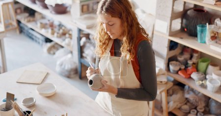Töpfer-, Kunst- und Designerin in einem heimischen Atelier, die an kreativer Arbeit arbeitet. Keramik-Designerin oder Studentin in einer Lernwerkstatt oder einem Haus, das ein Ton-Schablonenmuster für ein Vasenprojekt vorbereitet.