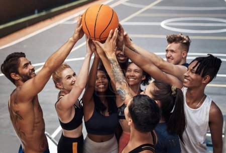 Téléchargez les photos : Basketball - its a team sport. a group of sporty young people standing together in a huddle around a basketball on a sports court - en image libre de droit