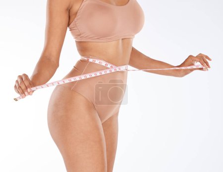 Photo for Tape, fitness and woman body isolated on a white background for lose weight or tummy tuck in underwear. Model person in lingerie, measure waist or stomach for liposuction results or health in studio. - Royalty Free Image