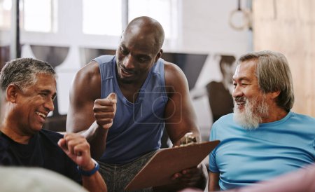 Foto de Gym, membership and personal trainer with men for sign up, planning and workout routine on blurred background. Health, checklist and coach with old people on floor for training, goals and motivation. - Imagen libre de derechos