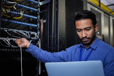 Engineer laptop, server room and cable connection for software update or maintenance at night. Cybersecurity coder, cloud computing and programmer man with computer for networking in data center