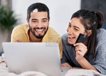 Photo for Financial wellness is the way to happiness. a young couple using a laptop and credit card together in bed - Royalty Free Image