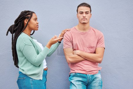 Interracial couple, wall background and argument in metro with black woman, question and conversation. Young gen z man, partner and conflict in city with relationship, fight and angry arms crossed.