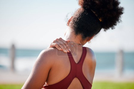 Foto de Medical, shoulder pain and fitness with black woman at beach for yoga, workout and exercise training. Burnout, injury and physical therapy with girl in city park for health, sport and pilates goals. - Imagen libre de derechos