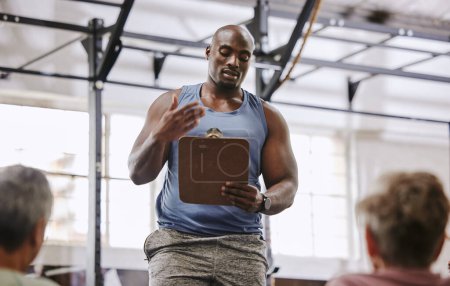 Foto de Coaching, gym checklist and black man talking to senior clients at training introduction, welcome or membership. Personal trainer fitness, workout or exercise schedule, sign up and USA community club. - Imagen libre de derechos