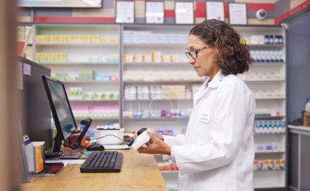 Foto de Order, pills and pharmacist scanning medicine at a checkout for service at a pharmacy. Healthcare, medical and woman on a hospital pc to scan a box for a prescription, inventory and medication check. - Imagen libre de derechos