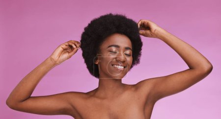 Black woman, touching and afro hairstyle on beauty studio background in relax skincare, texture maintenance or salon wellness. Model, natural and hair growth hands on isolated pink or makeup backdrop.
