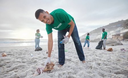 Foto de Retrato voluntario, limpieza de playa u hombre para reciclar botellas de plástico para servicio comunitario, contaminación y día de la tierra. Sonríe, equipo de ONG o basura de arena para el cambio climático, la naturaleza y ayudar al medio ambiente. - Imagen libre de derechos