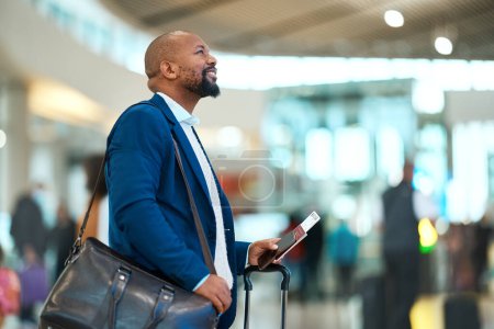 Photo for Passport, flight and businessman standing in the airport checking the departure times or schedule. Travel, work trip and professional African male waiting by terminal with his ticket to board plane - Royalty Free Image