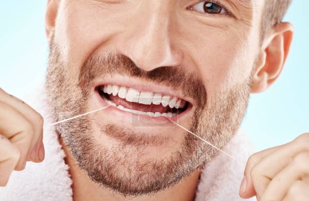 Téléchargez les photos : Dental care, health and man flossing teeth in studio for oral wellness or tooth grooming. Dentistry, healthy and closeup of male model doing fresh, clean and natural mouth routine by white background. - en image libre de droit