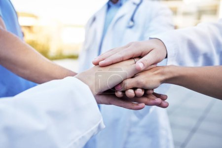 Healthcare, solidarity and hands of doctors for support, partnership and medical success. Teamwork, trust and team of employees in medicine with a gesture for motivation, commitment and goal.