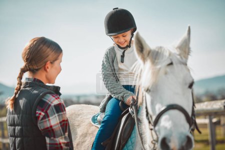 Foto de Learning, hobby and girl on a horse with a woman for fun activity in the countryside of Italy. Happy, animal and teacher teaching a child horseback riding on a field as an equestrian sport in nature. - Imagen libre de derechos
