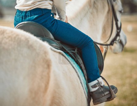 Téléchargez les photos : .Sports, riding and shoes of girl on horse in countryside for hobby, equestrian and learning. Cowgirl, summer and pasture with child jockey and pet on animal ranch for summer, vacation and adventure - en image libre de droit
