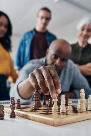 Photo for Protect the king at all costs. a mature businessman playing chess in his office with his colleagues rooting and watching in the background - Royalty Free Image