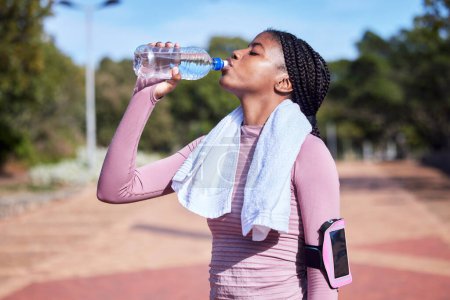 Téléchargez les photos : Fitness, black woman and drinking water for hydration, training and exercise for wellness, healthy lifestyle and workout. African female athlete, lady and runner with bottle, aqua and liquid for rest. - en image libre de droit
