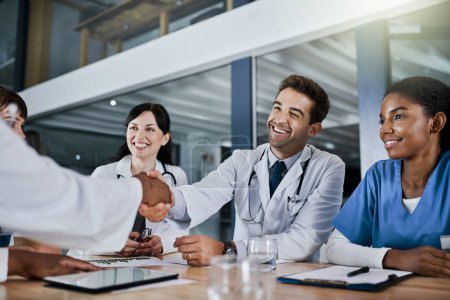 Photo for Their hospital hires only the best. doctors shaking hands during a meeting in a hospital - Royalty Free Image