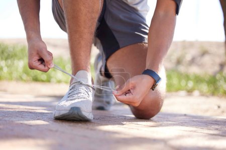 Téléchargez les photos : Fitness, exercise and man tie shoes ready to start running, marathon training and endurance workout. Sports, nature trail and feet of male runner tying shoelace for wellness, health and performance. - en image libre de droit