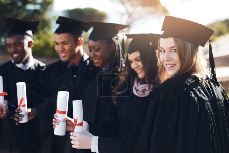 Photo for The best way to predict the future is to create it. Portrait of a group of students standing in a line on graduation day - Royalty Free Image