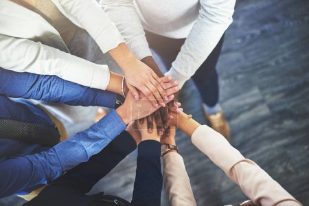 Téléchargez les photos : The secret is always teamwork. a group of businesspeople putting their hands together in a huddle - en image libre de droit