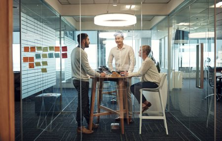 Téléchargez les photos : Discussing tasks for the day. businesspeople having a meeting in the office - en image libre de droit
