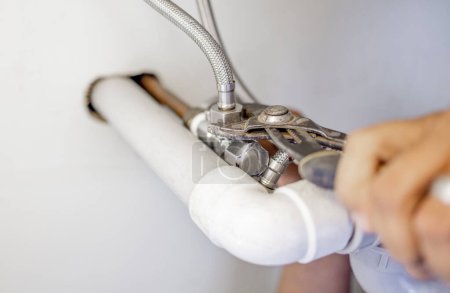 Téléchargez les photos : Plumber, pipes and man hands with pliers for maintenance, renovation or builder service. Closeup handyman, pipeline and plumbing tools for bolt, valve and installation of faucet system, tap or repair. - en image libre de droit