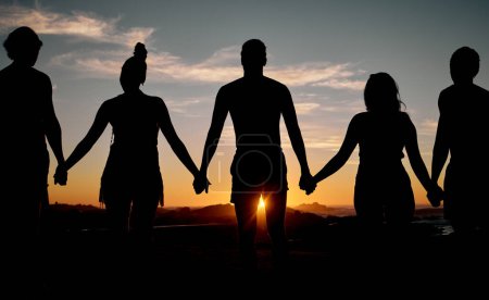 Téléchargez les photos : Friends, bonding or holding hands on sunset beach silhouette, nature freedom or community trust support. Men, women or people sunrise shadow in solidarity, team building help or travel mission goals. - en image libre de droit