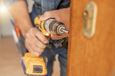 Locksmith, maintenance and handyman with drill, home renovation and fixing, change door locks with power tools. Construction, building industry and trade with manual labour, diy and house repair.