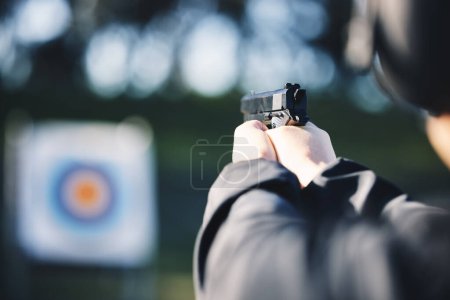 Téléchargez les photos : Gun, target and person training outdoor for shooting range, game exercise or sports event closeup. Hands with firearm and circle for aim, vision and practice, police learning academy or field gaming. - en image libre de droit